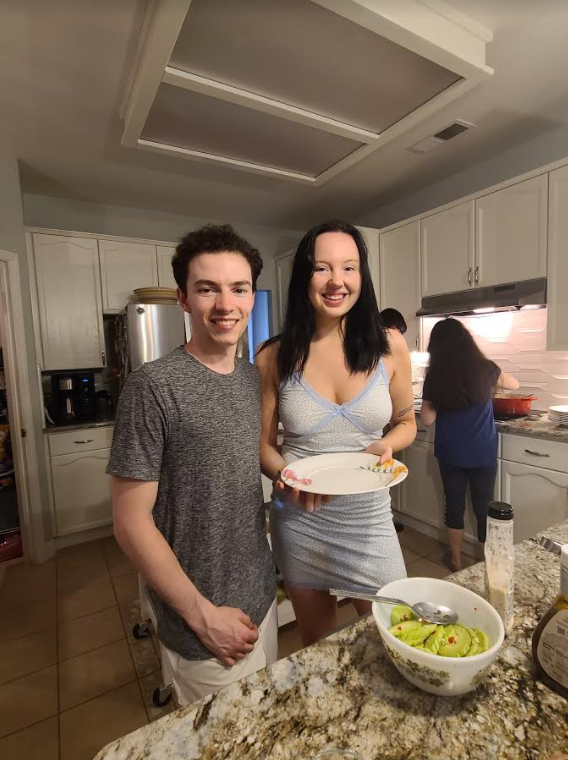 Image of young lady and gentleman in a kitchen with a salad in front of them