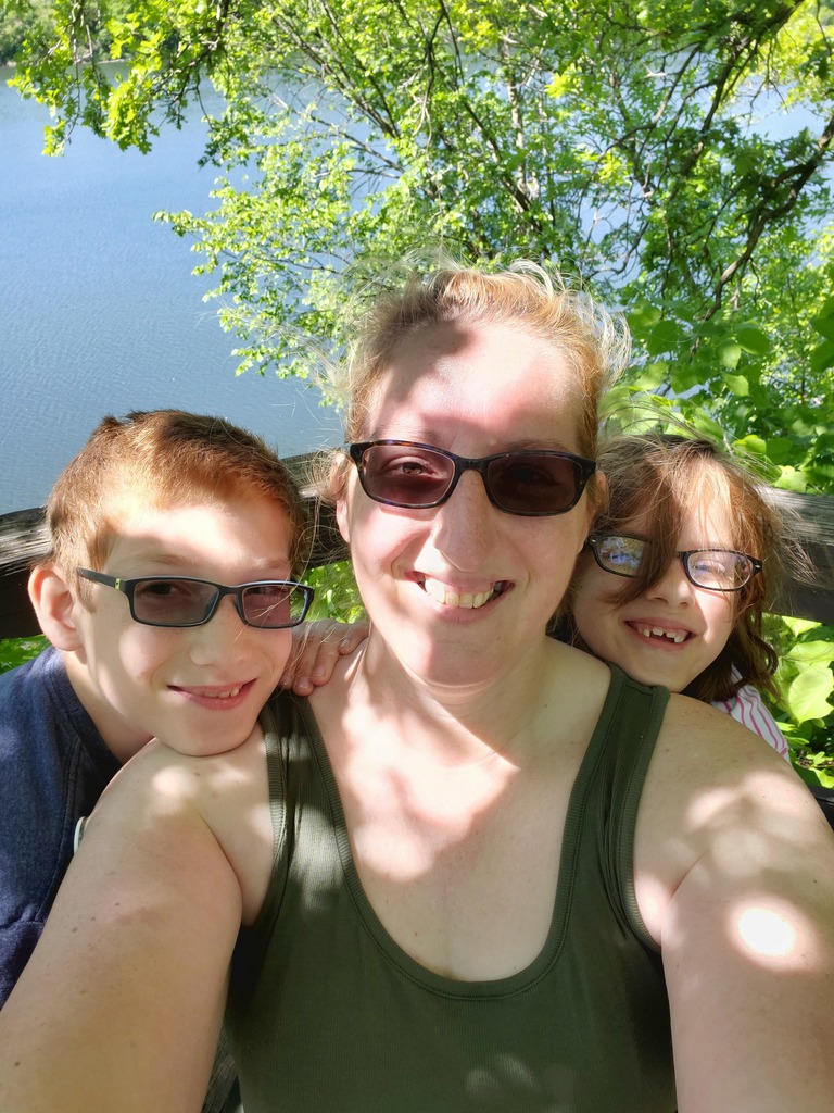 Woman and two children taking a selfing in front of a lake