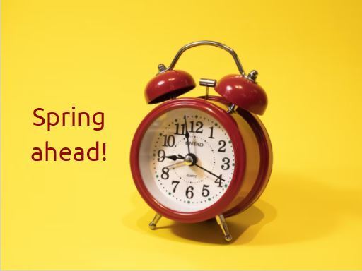 Yellow background with red clock and text "Spring Ahead"
