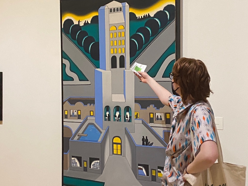 A student describes the lines in a painting of a building with colors of grey, yellow and teal