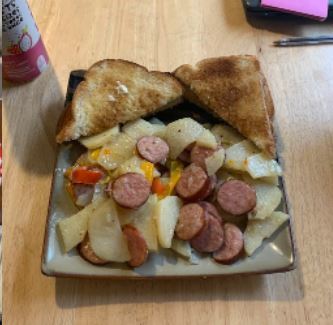 Image of plates sausage, onion, and potato bake with toast points. 