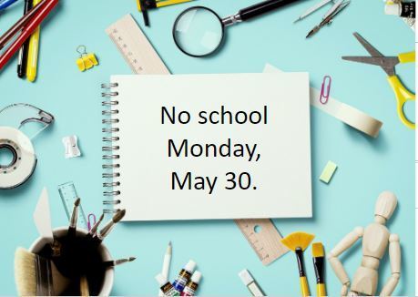 paintbrushes, magnifying glass, ruler, paper clip, pencils, and scissors on a blur background with text on a notebook that reads "No school Monday, May 30."