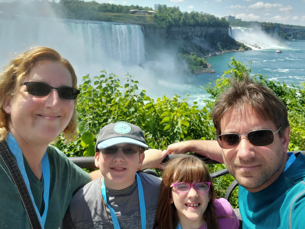 Two adults and two children in front of Niagara Falls
