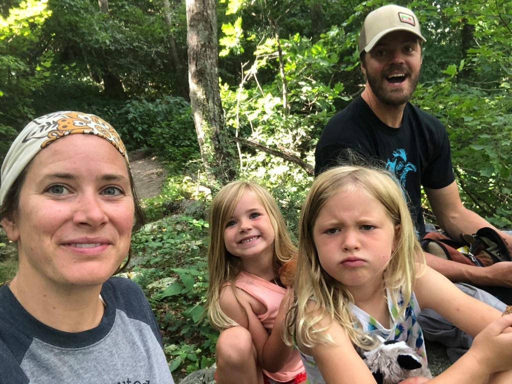 A mom and dad and two kids in the woods