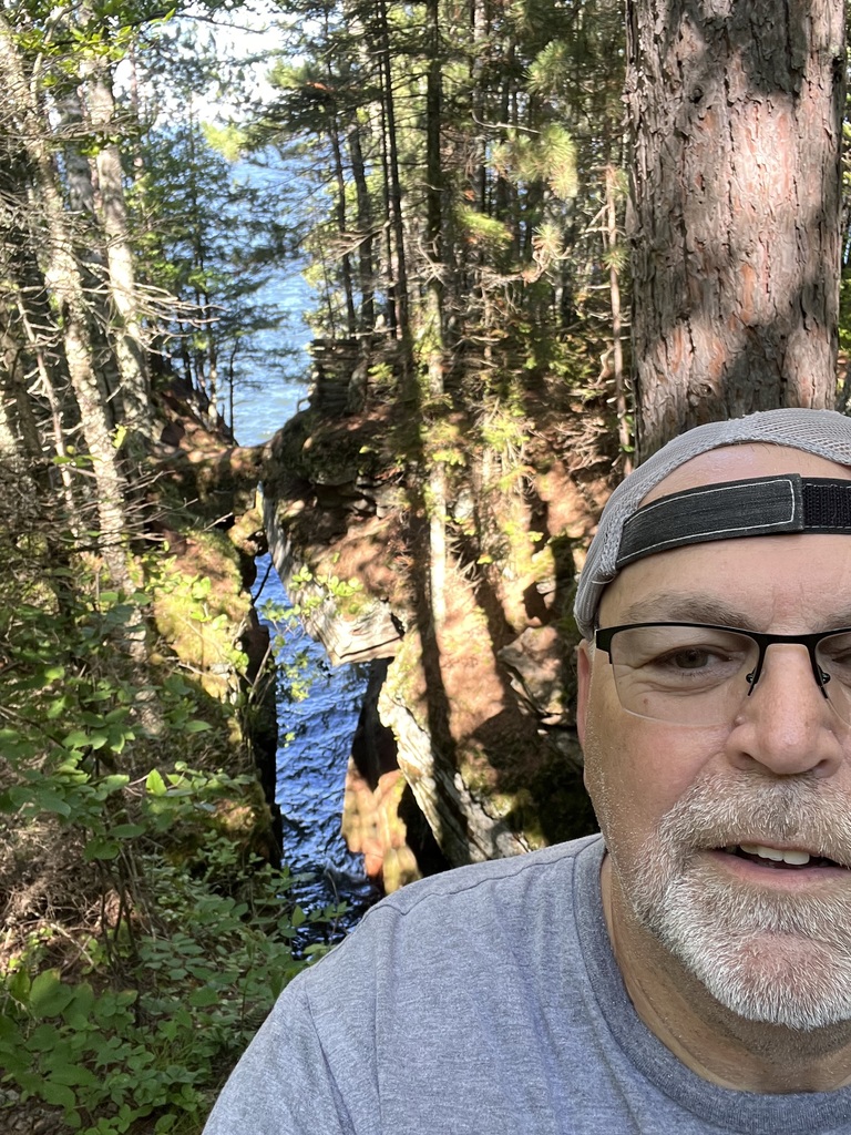 selfie of man with gorge at apostle islands in the background