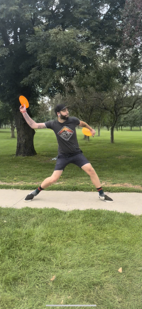 man throwing frisbee in park