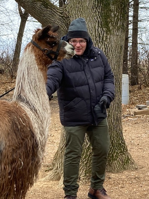 Image of advisor Larry petting a llama. 