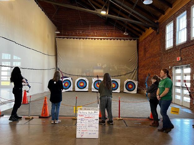 Image of students at an doing archery