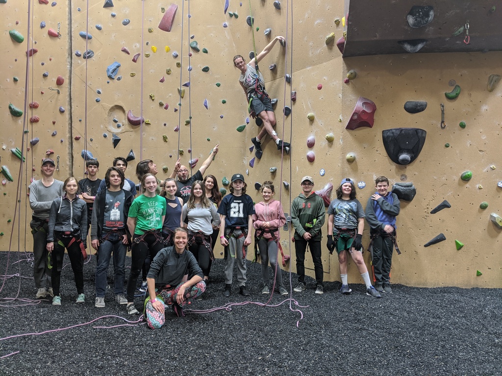 Group of students in front of rock climbing wall