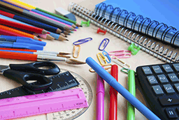 image of school supplies, colored pencils, notebooks, calculator